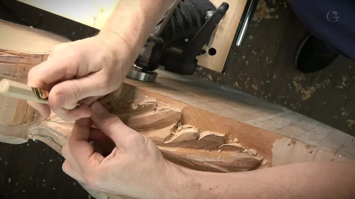 Both hands steady a pale handle with a brass ring near the left end of the leaf