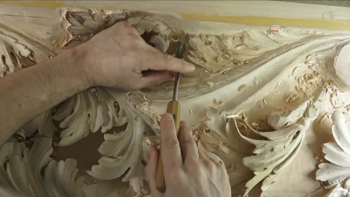 Fingertips of the left hand rest on the thin shank.