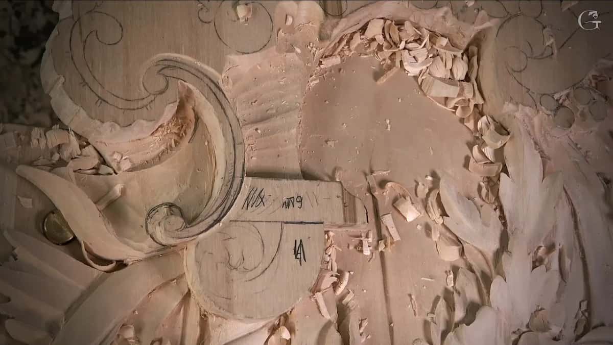 Pencil marks cover the block beside the volute, shavings lying around it