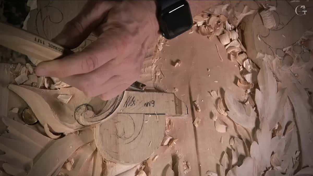 Fingers steady a slim gouge along the edge of the block with its 6 mm note