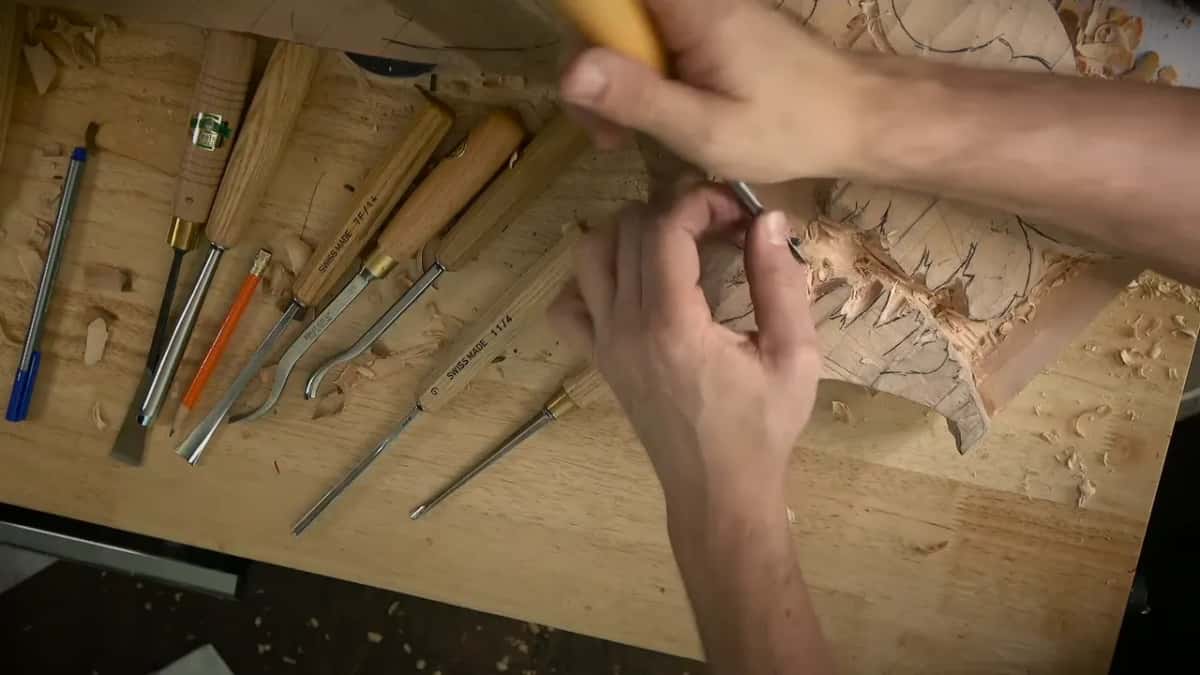 Fingers of the left hand guide the blade at the top edge while the right hand pushes the handle