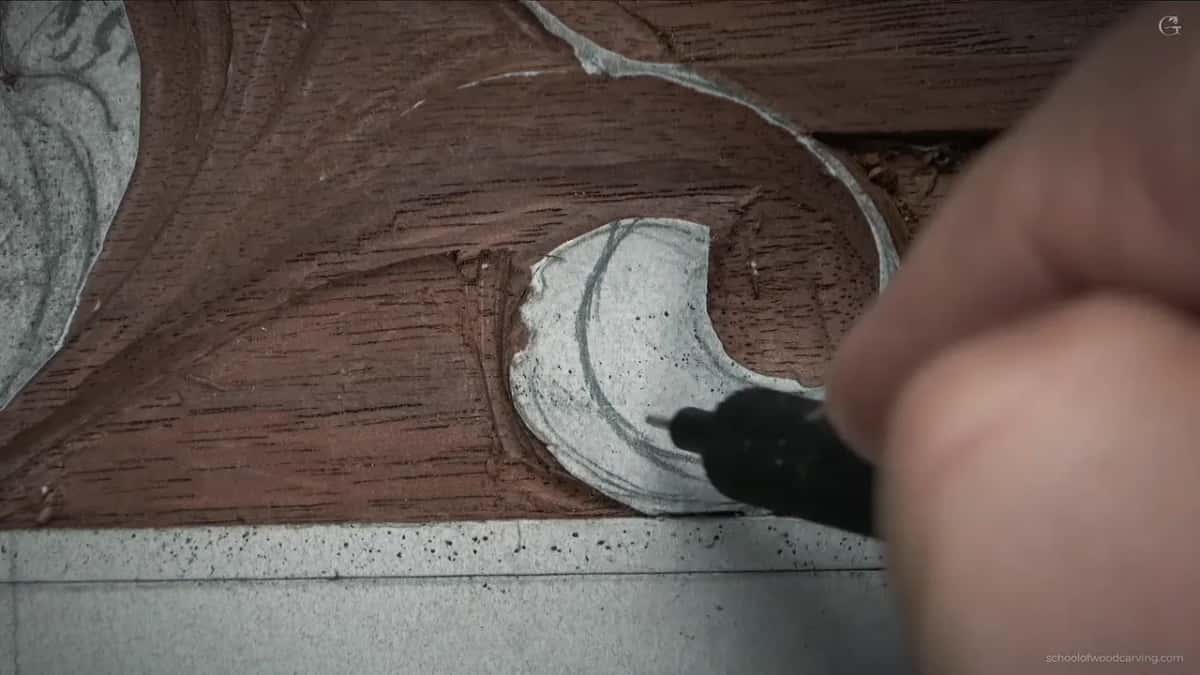 Black drawing tool on a paper covered leaf above the molding