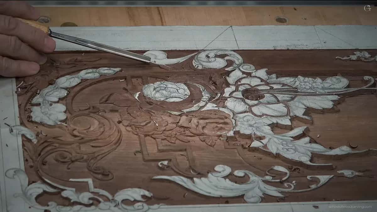 Whole panel from above with the paper pattern still on the ornament and one tool coming in at the upper left