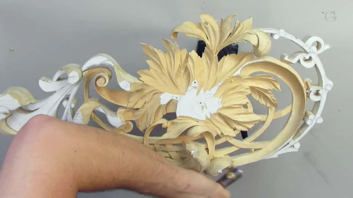 Forearm across the bottom of the frame, its hand holding a tool by the panel's edge
