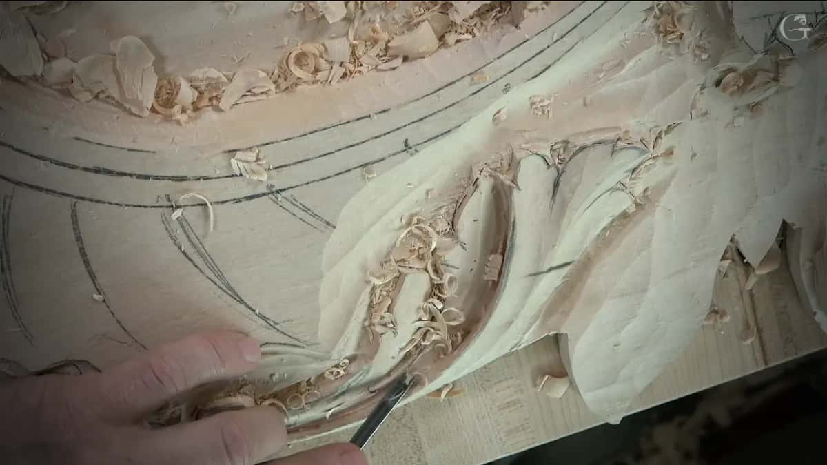 Small gouge low on the leaf, left hand guiding it close to the curl