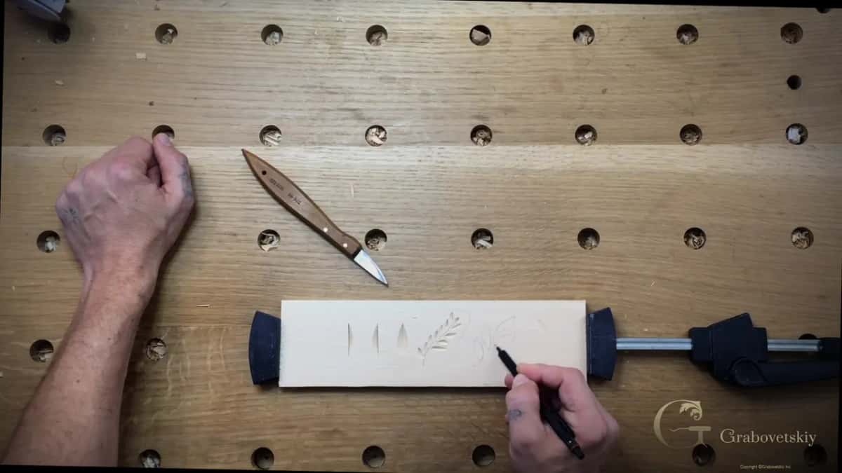 Leaves drawn a little bigger on the clamped board, the knife lying ready beside them
