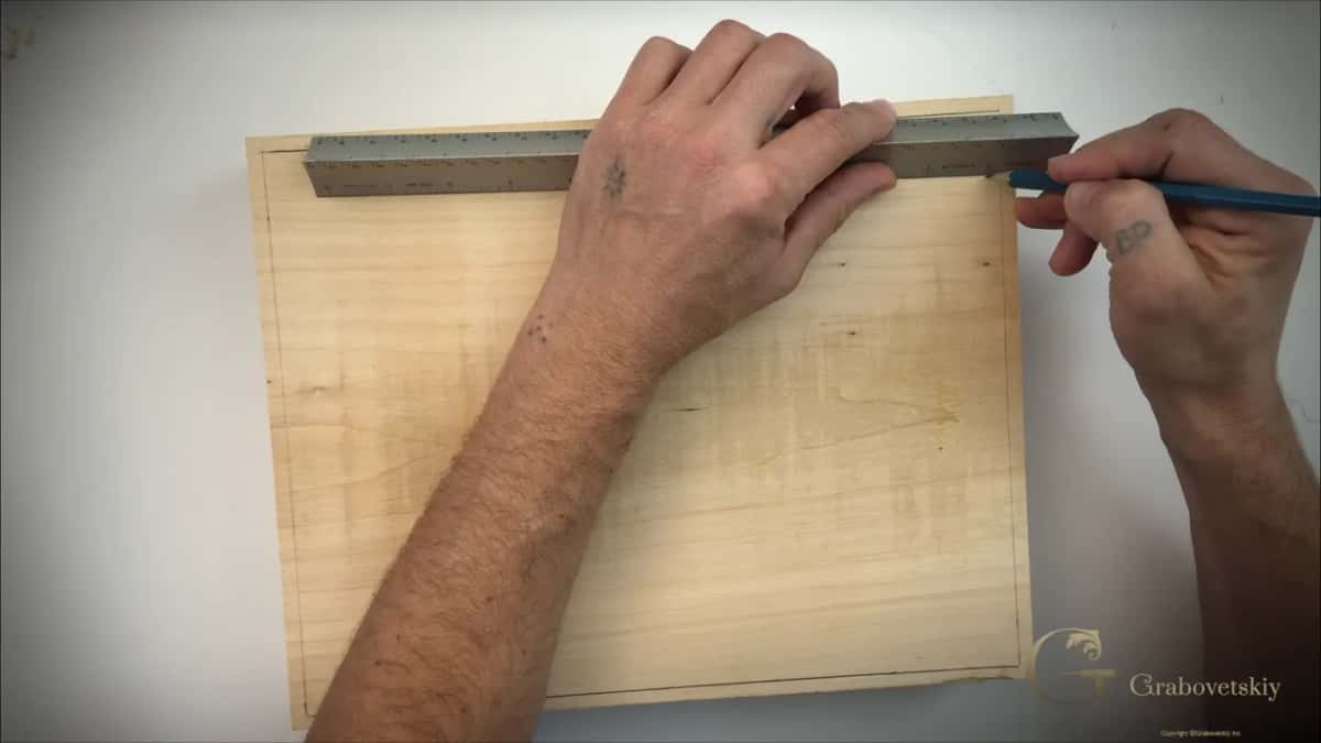 Metal ruler along the top while the pencil draws, with one line so far around the board