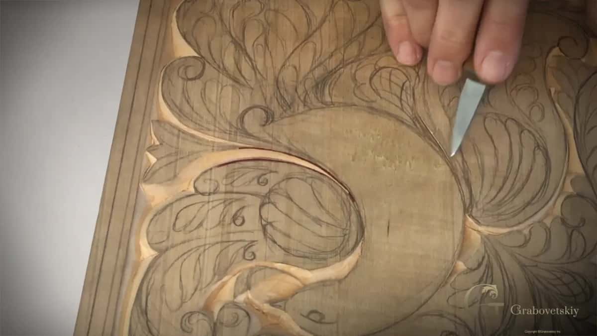 Tip of the blade set on a pencil line beside the round body of the bird