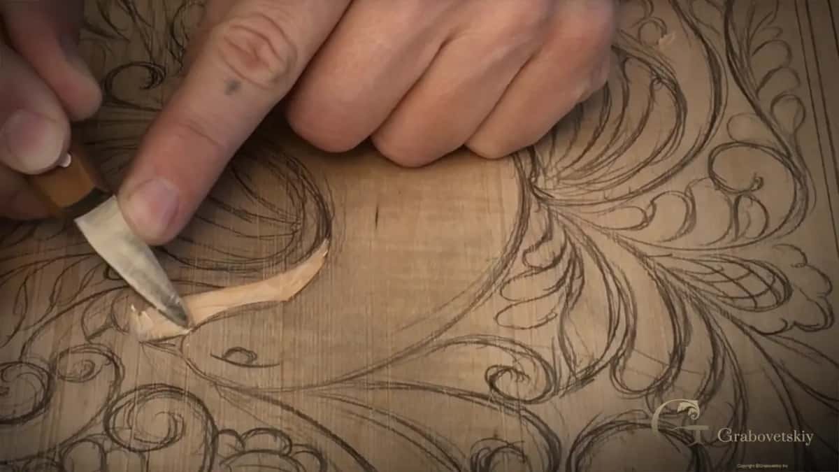 A pale chip curling up along the wing line right at the point of the knife
