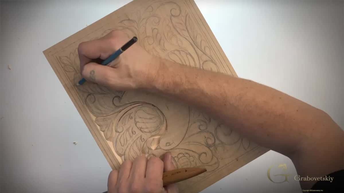 Pencil drawing a line near the corner while the other hand holds the knife