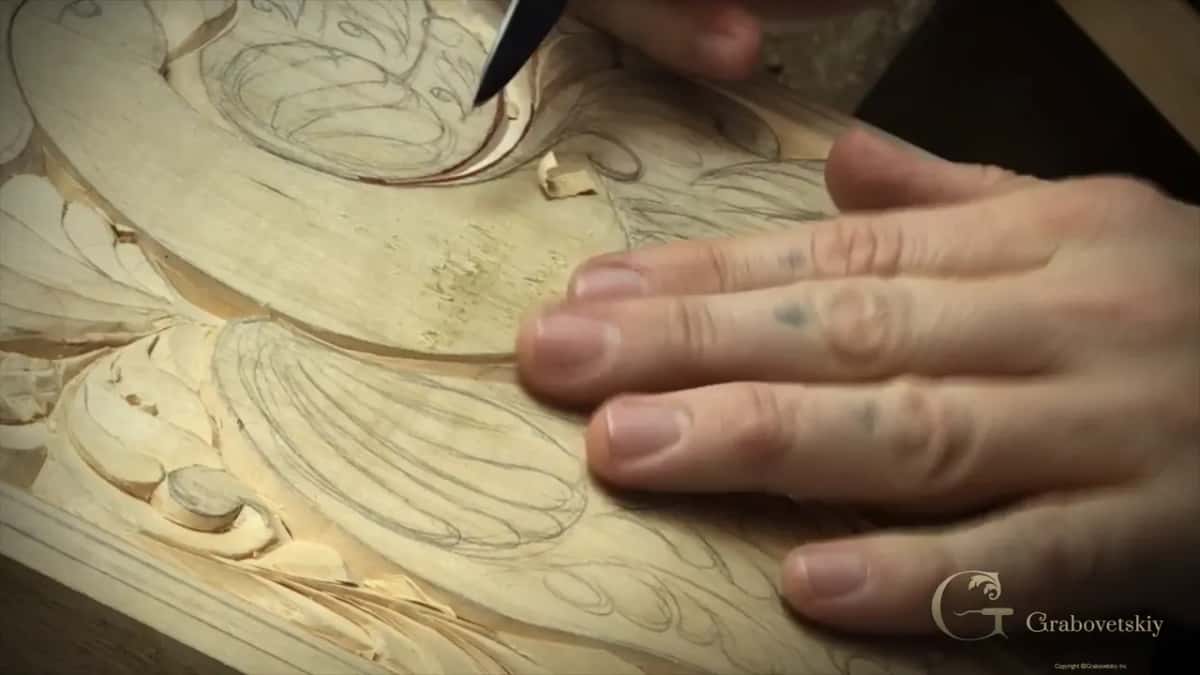 Fingertips flat on the board, the tip of the knife above them