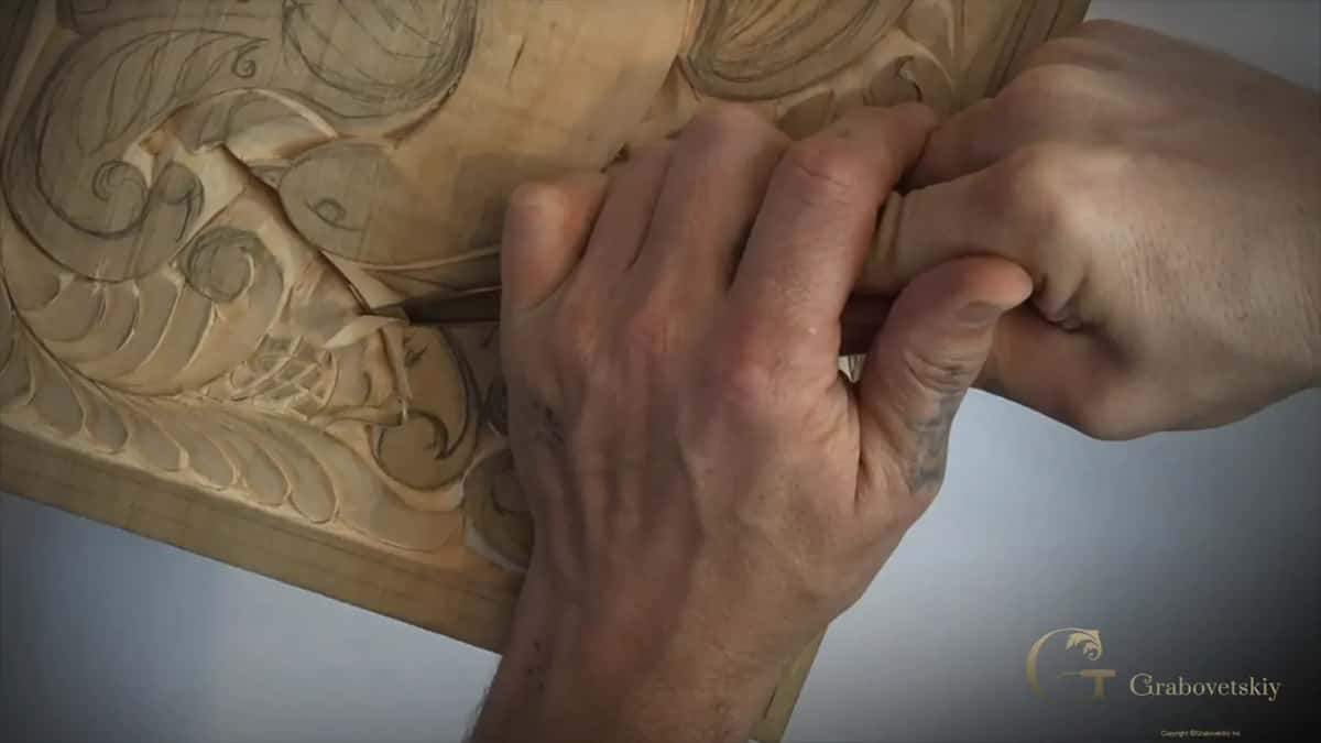Both hands steady a knife held low and flat