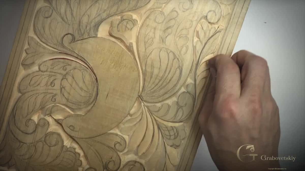 Right hand closed against the side of the board, pencil lines still on every leaf