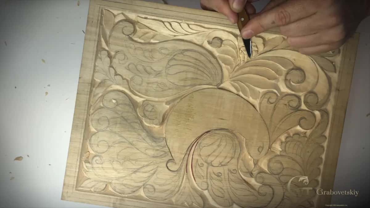 Board standing upright, both hands on the knife at its top edge