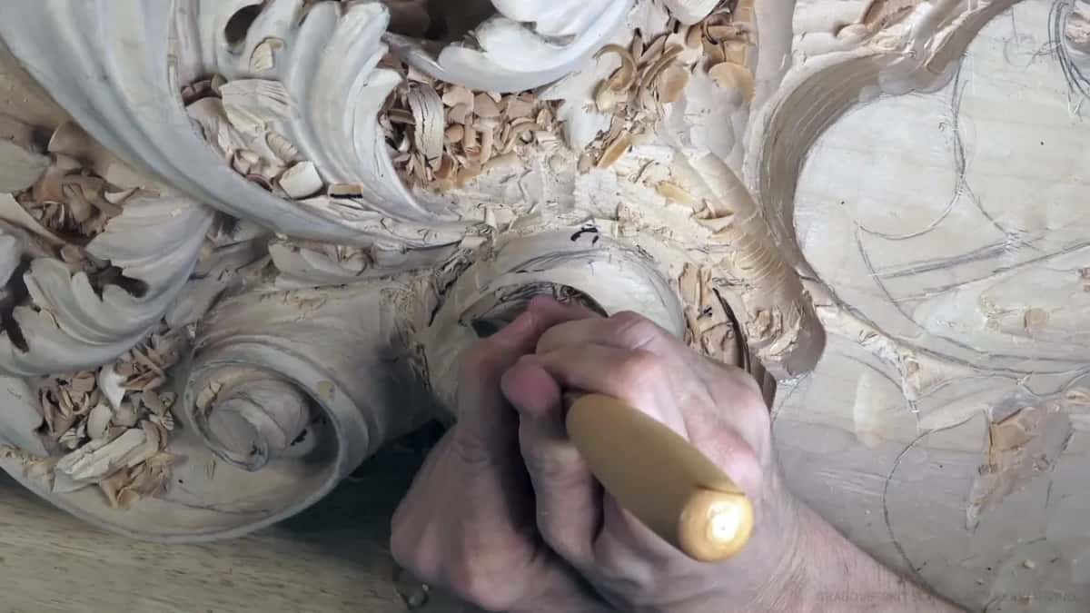 Both hands on one gouge, working inside the head.
