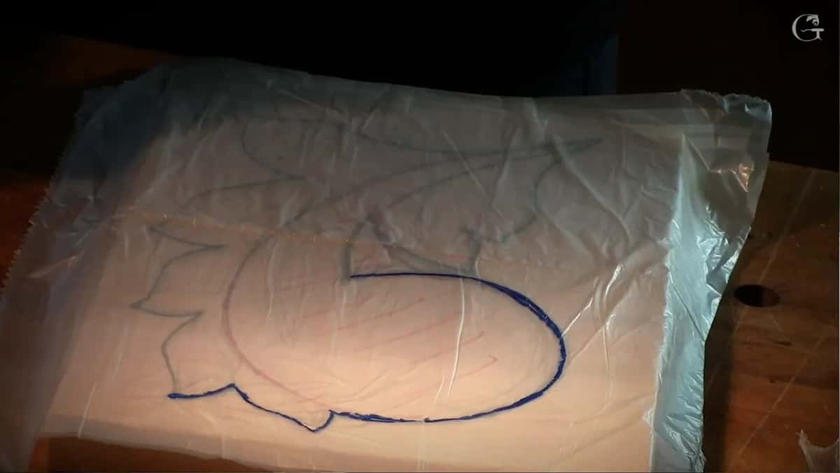 Plastic laid over the drawing, the first outline traced on it in blue
