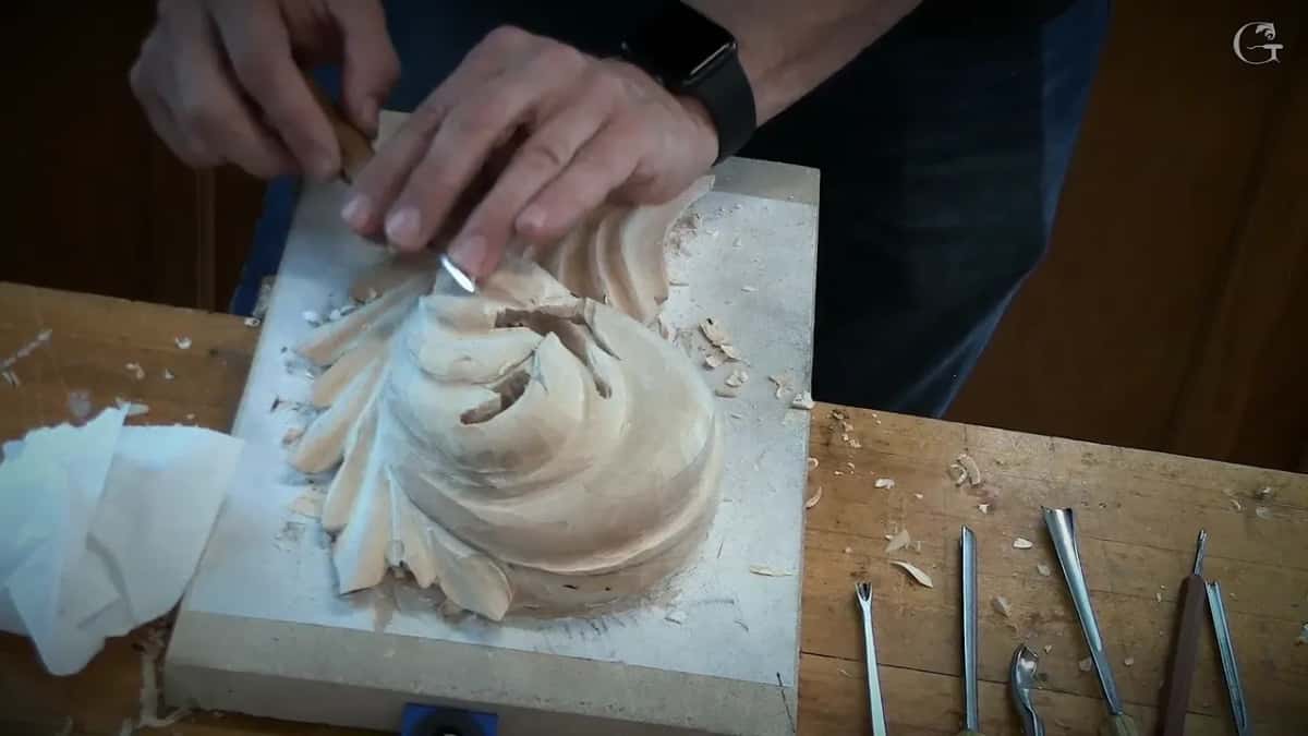 Working near the top edge of the leaf, tissue paper lying at the left