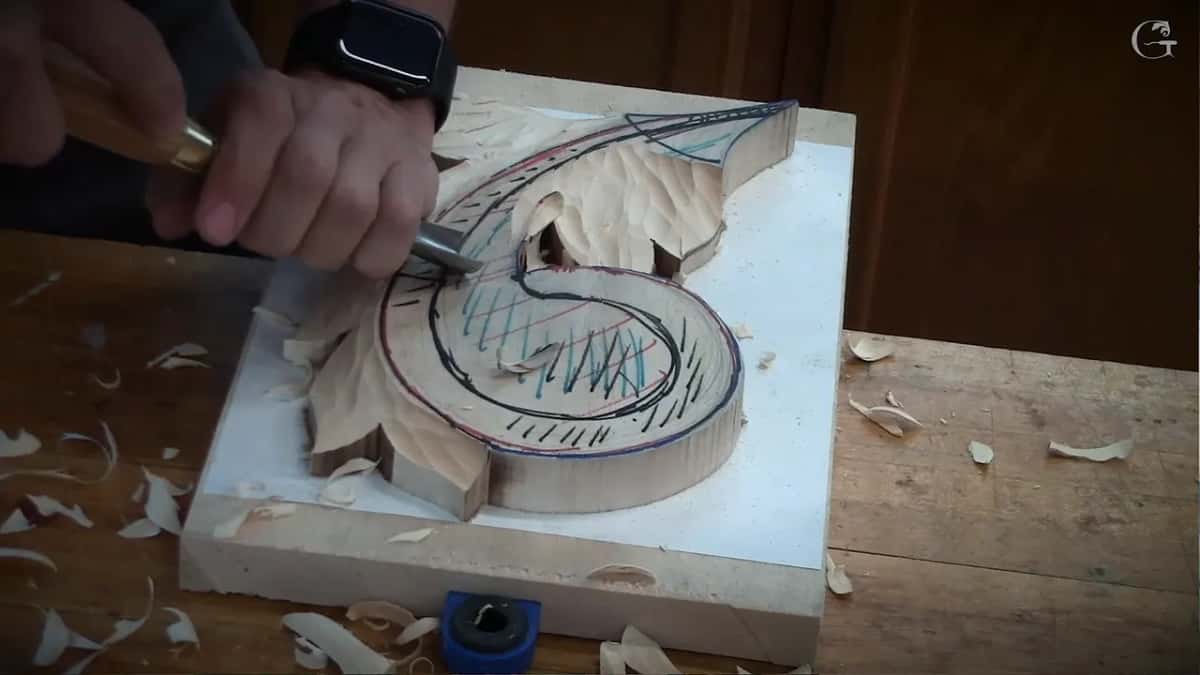 Low at the inner edge of the scroll, a gouge beside the roughed leaves