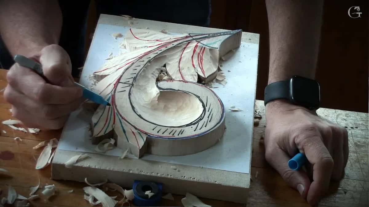 Blue marker drawing among the red lines, its cap held in the other hand