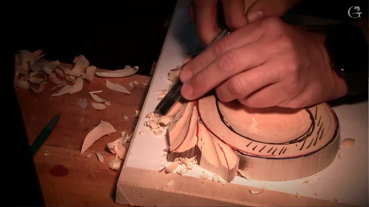 Warm light, a gouge in the lower leaves and chips piled on the bench beside the board