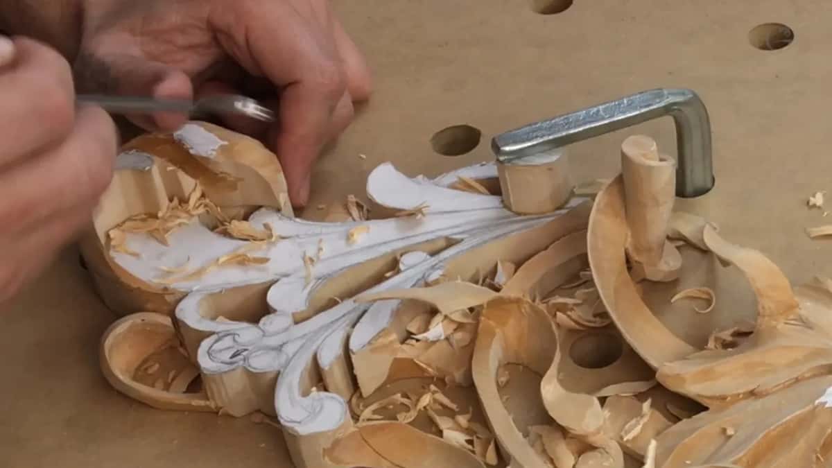 Two hands on one small tool at the curled end, chips heaped around