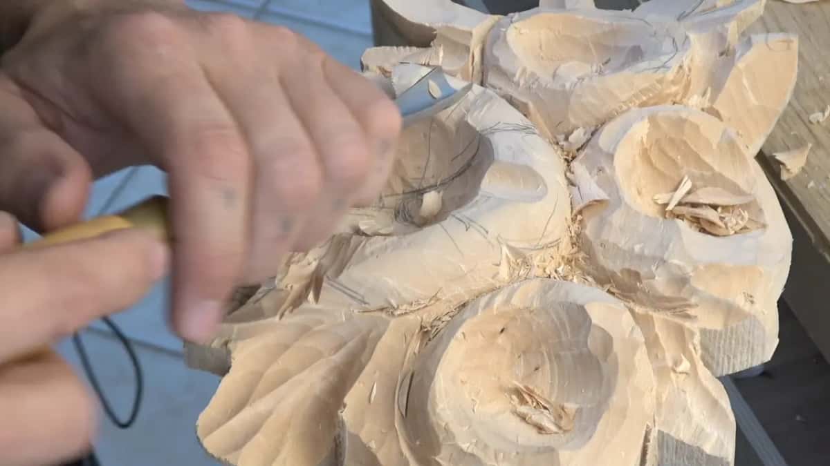 Both hands on one tool at the rim of a flower bowl, pencil marks inside it