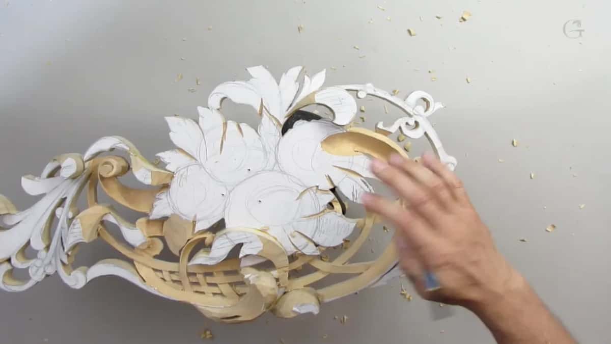 One hand rests flat on the panel beside the curved basket straps, chips scattered around