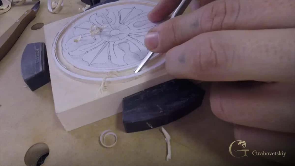 Curls lie around the groove as a small tool works in it.