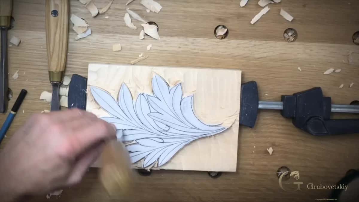 A brush sweeping chips off the paper leaf and the lowered ground