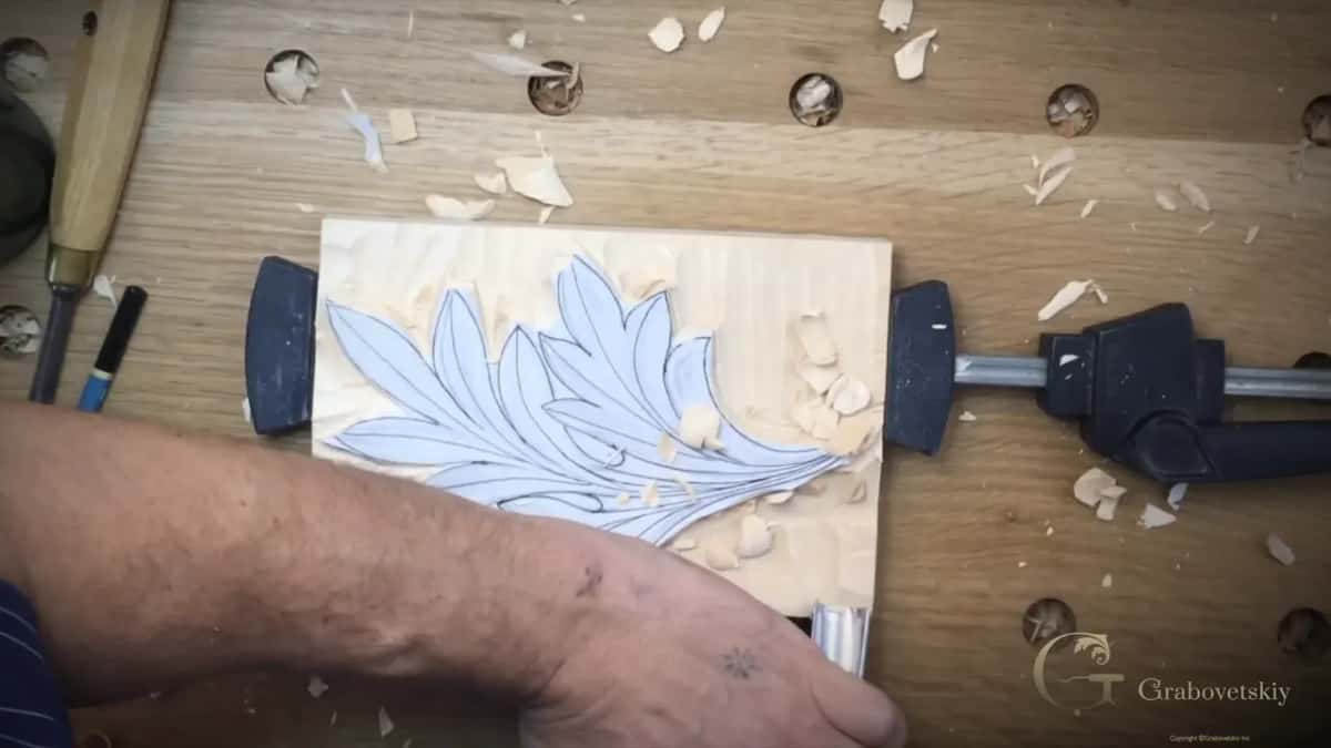 Forearm across the bench while a tool works along the lower edge of the leaf