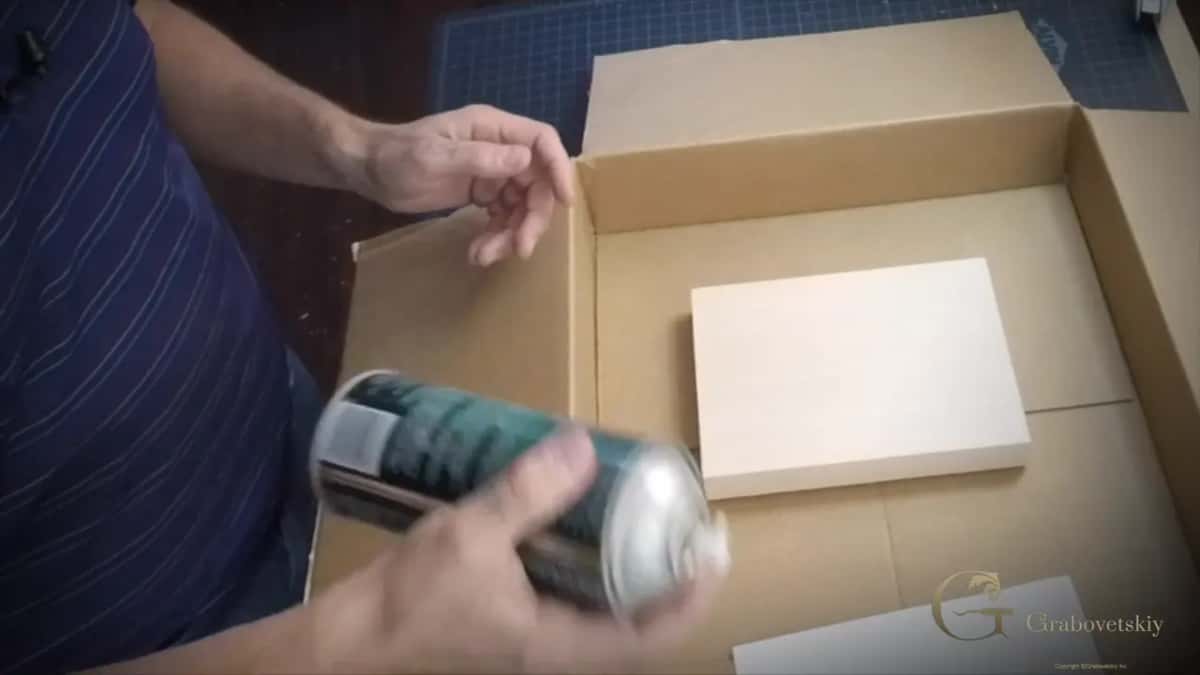 Spray can over the block in a cardboard box