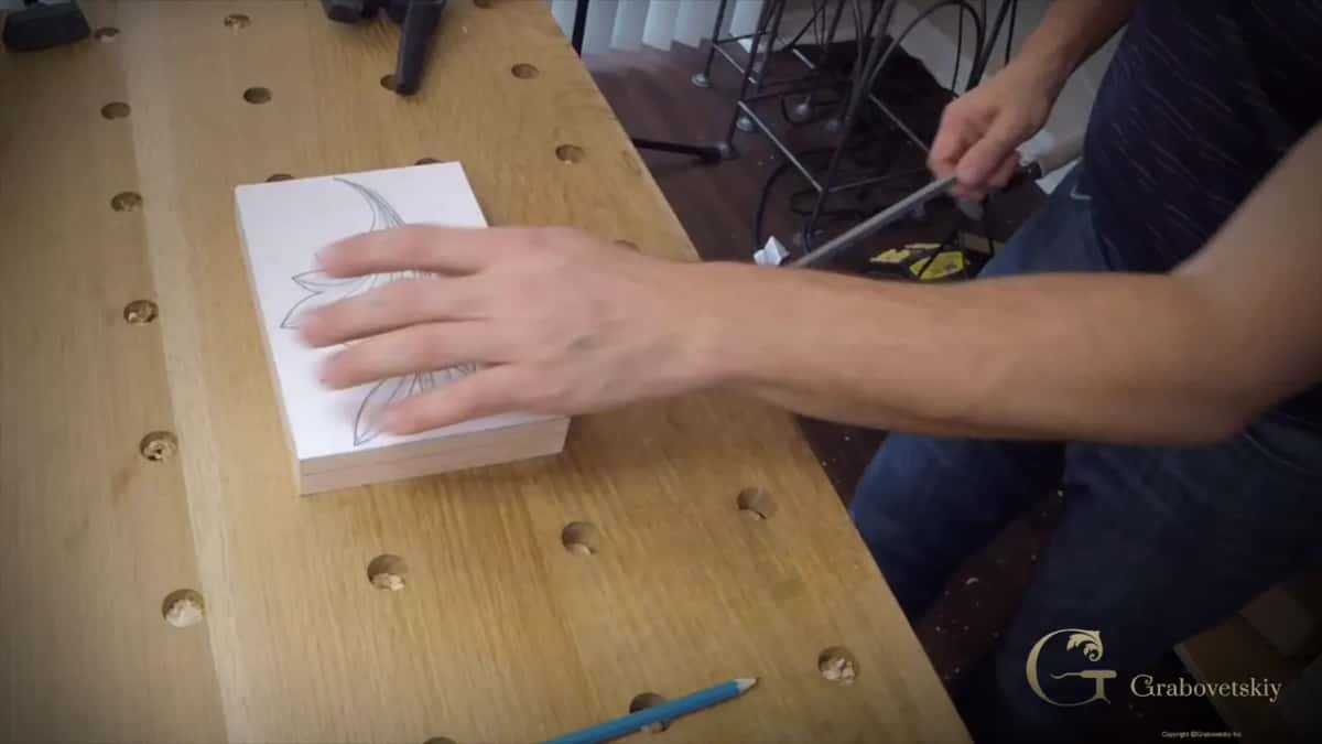 One hand pressing the glued drawing flat