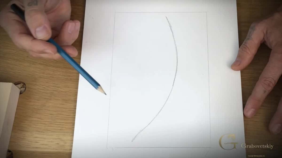 Blue pencil drawing the first long curve inside the traced border of the block