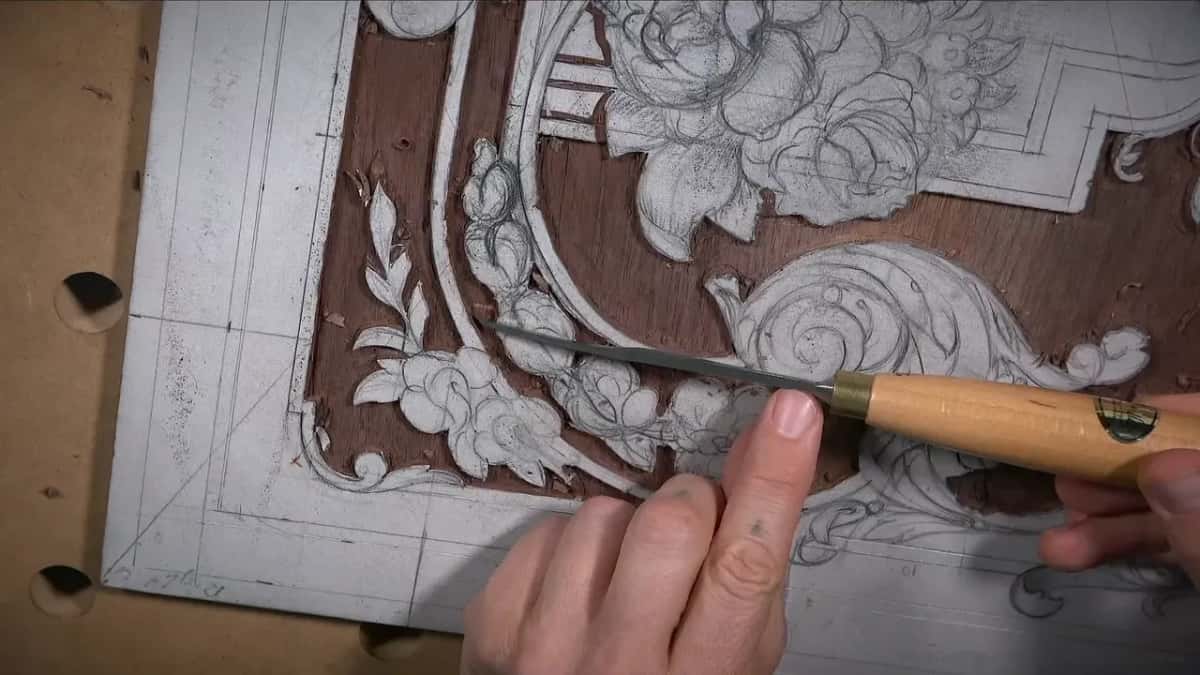Long thin blade with a light handle and brass ferrule, reaching in beside the scroll