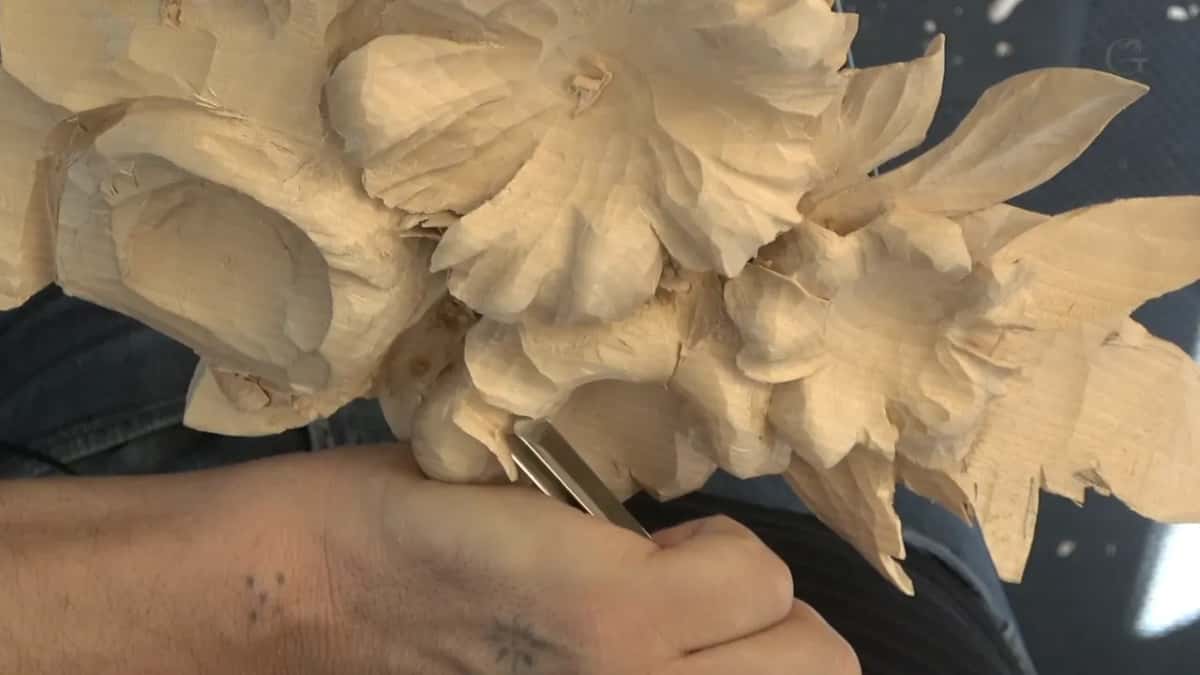 Flat-sided steel slides under the edge of a flower