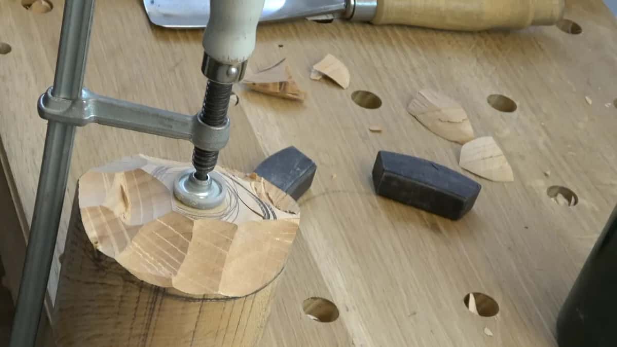 The block's top tapers in under the screw clamp pad, faceted by gouge marks