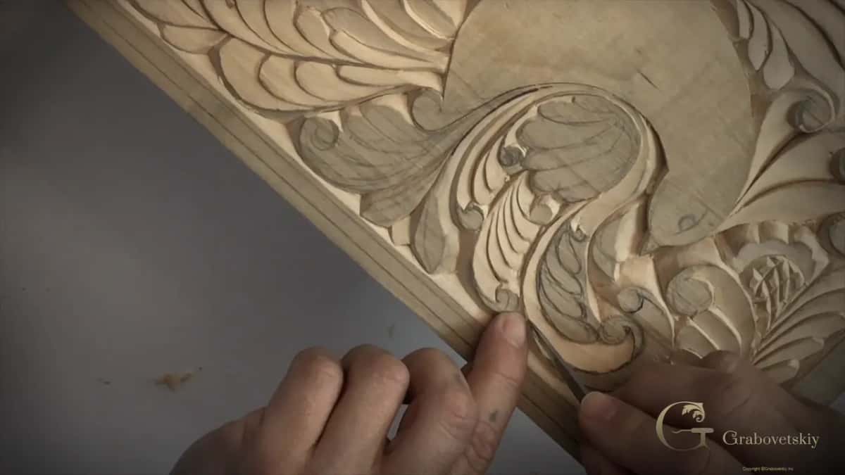 Two hands at the lower edge, knife at a curl