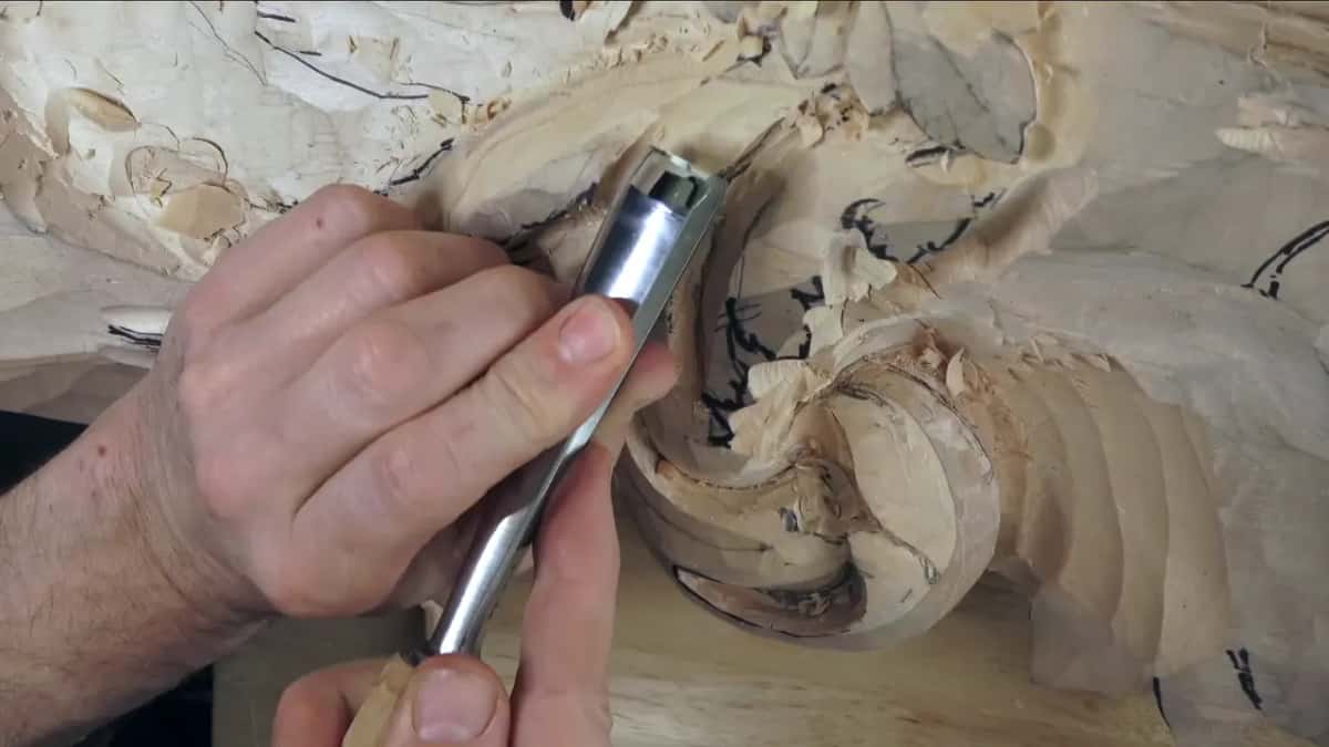 Chrome ferrule, fingers wrapped around it, edge pressed against the roll.