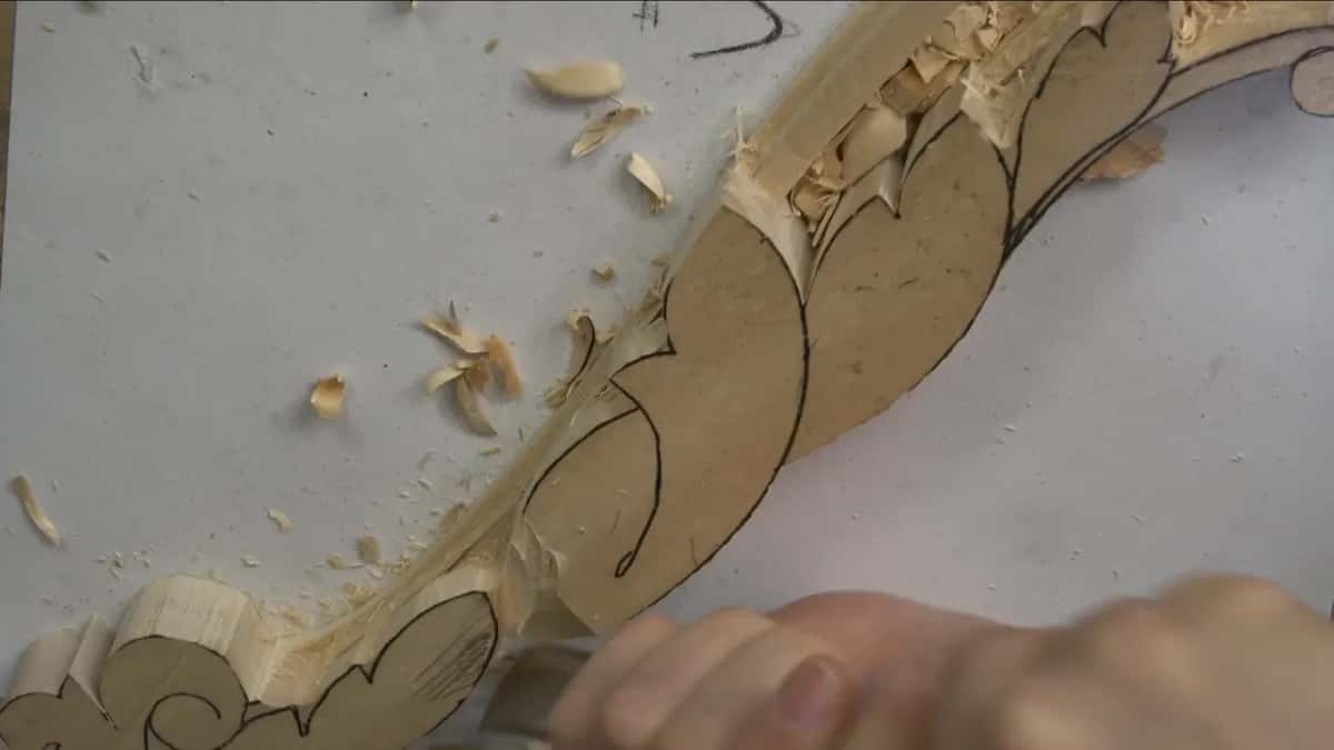 Shavings curl up where my hand pushes the tool along the far end of the line.