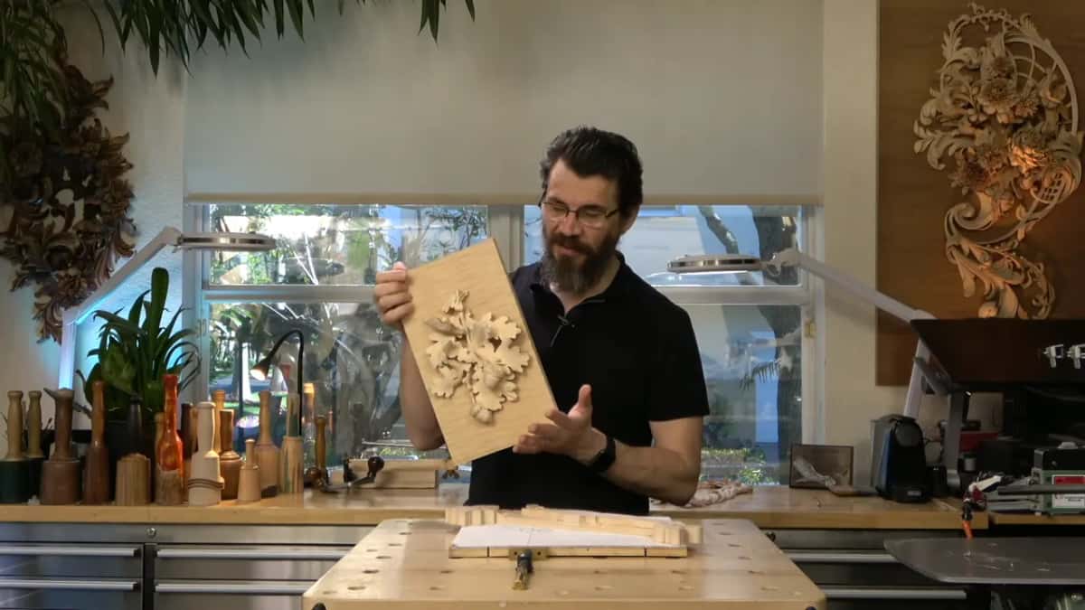 Holding up a carved panel.