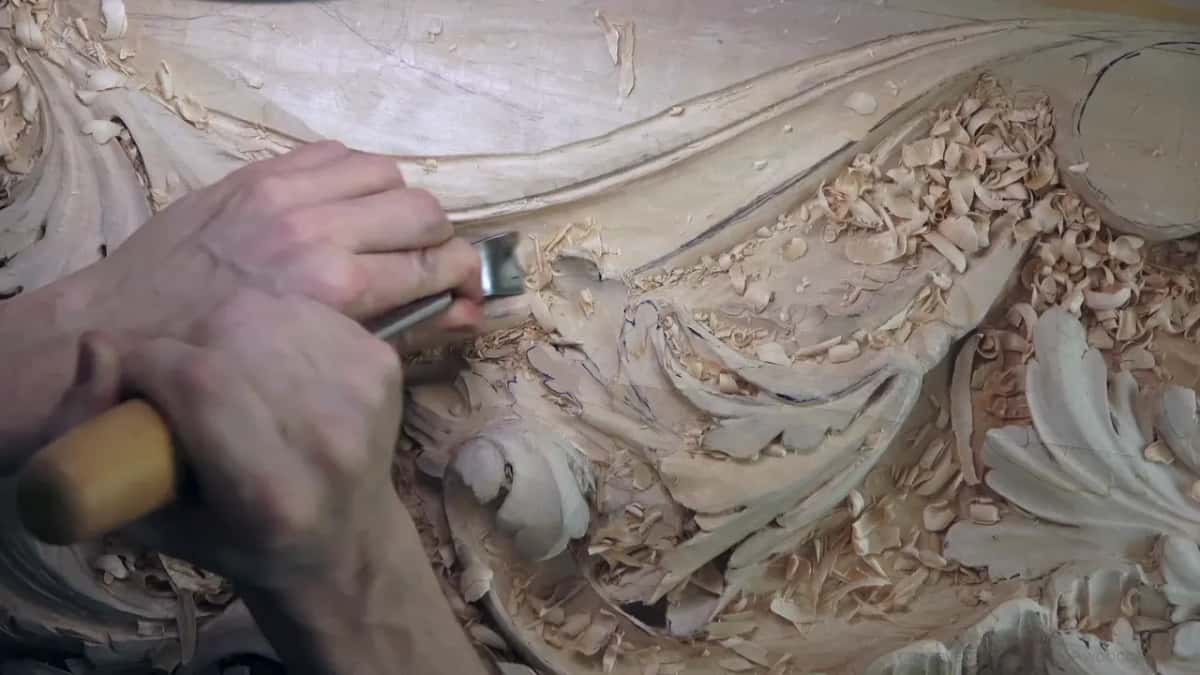 Two hands drive a gouge down the length of the hollow.