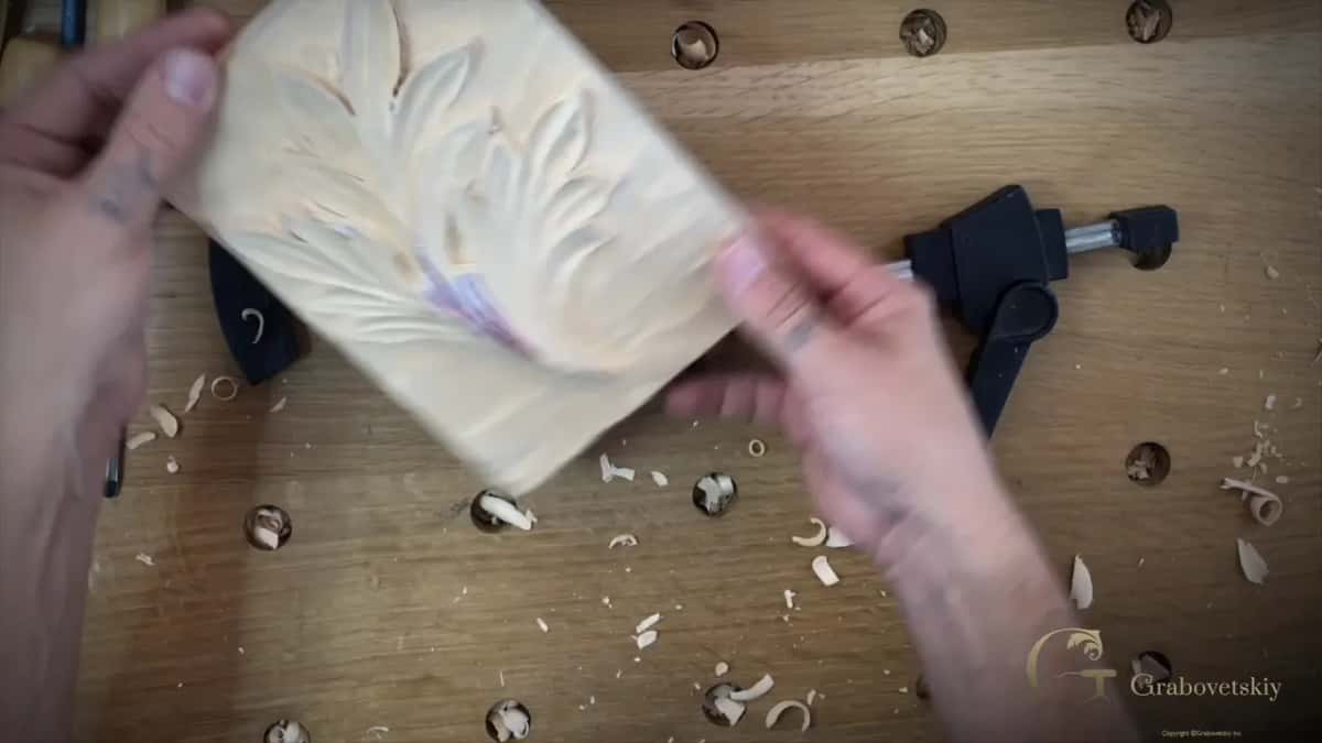 Both hands lifting the block away from the clamp to turn it round