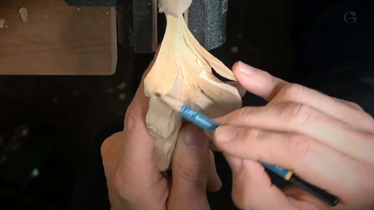 Blue detailing tool held like a pencil