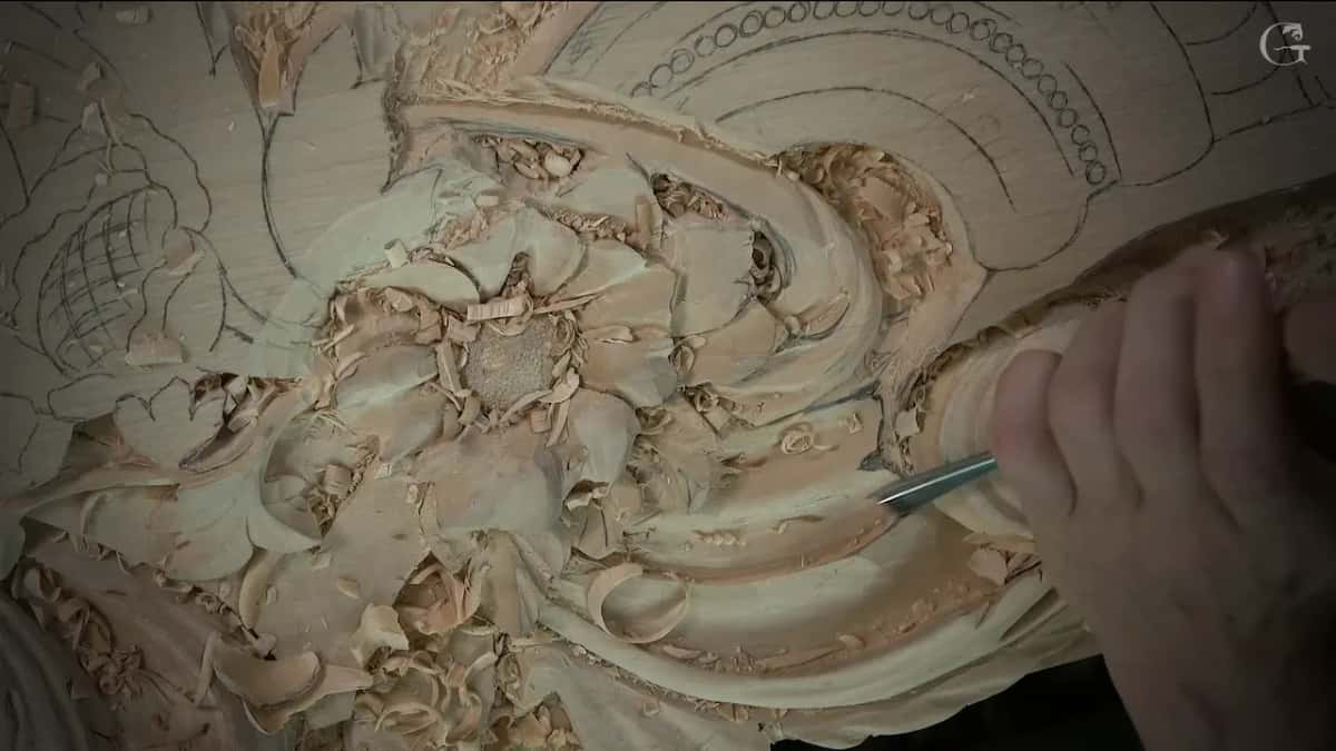 Hand pressing a tool into the hollow on the right side of the scroll