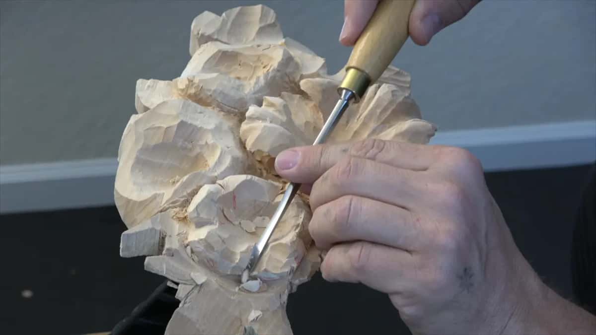 Wood handle and brass ferrule up top while the other hand guides the steel into a flower