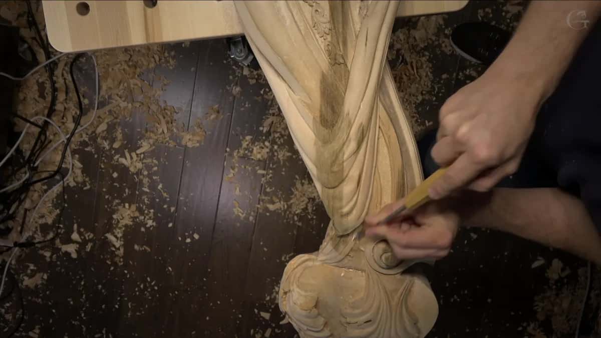 One gouge, two hands, low on the drape near the spiral and the chips.
