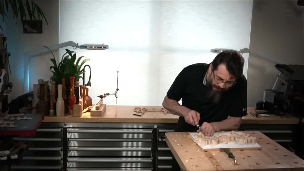 Leaning over the bench, both hands held in close on the tool