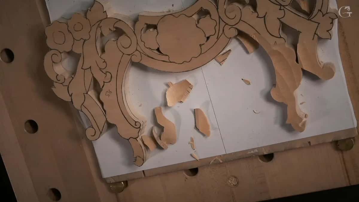 Sawn blank with the paper pattern still glued to its face, chips scattered across the bench around it