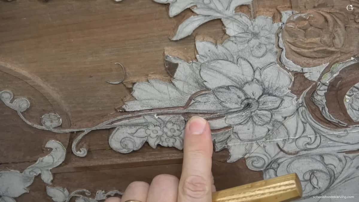Fingertip resting on the penciled bloom while a yellow handle waits at the bottom edge of the frame