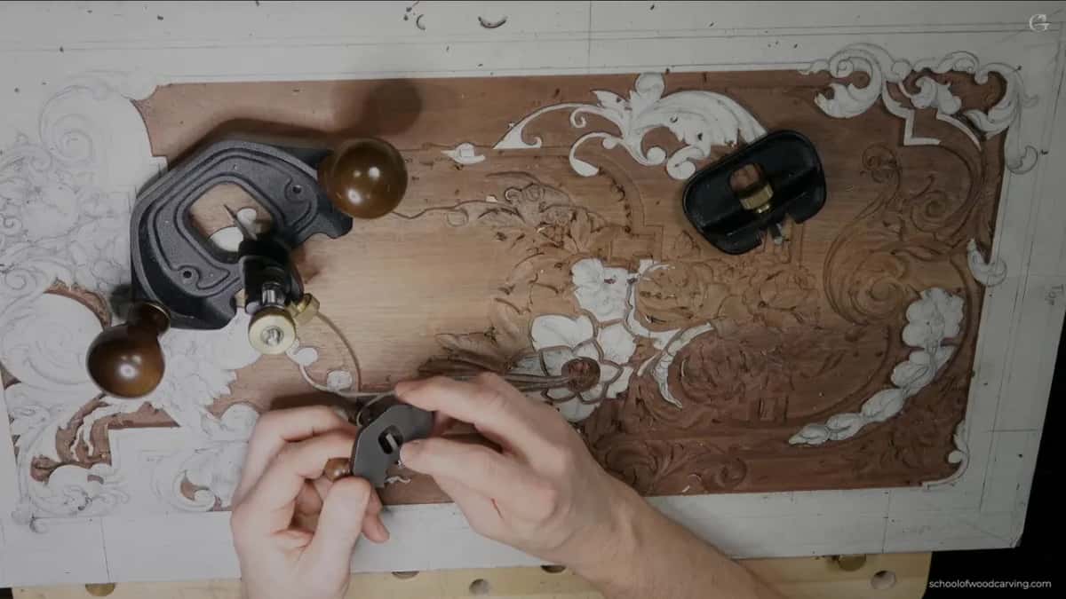 Three router planes resting on the panel while both hands hold the smallest of them.